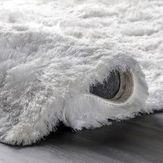 an area rug with white fur on the floor