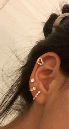 a woman with three ear piercings on her left ear and one in the middle