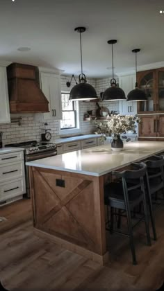 a large kitchen with an island in the middle and lots of stools around it