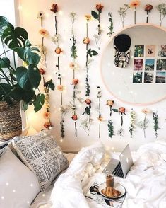 there is a bed with flowers on the wall and a laptop in front of it