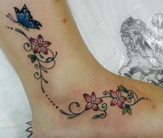 a woman's foot with flowers and a butterfly on it