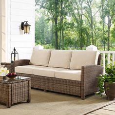 an outdoor living room with wicker furniture