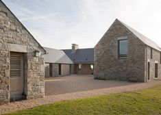 a stone house sitting on top of a lush green field