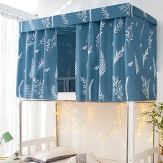 a bunk bed with blue curtains and lights on the top is in front of a window