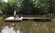 a woman standing on a dock next to a dog