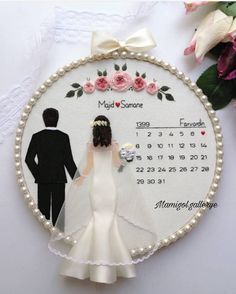 a wedding ornament with a bride and groom on the calendar for their date