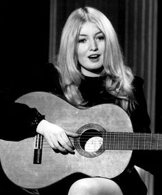 a woman holding a guitar in her right hand