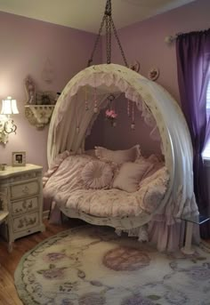 a canopy bed in the corner of a room with pink walls and purple drapes