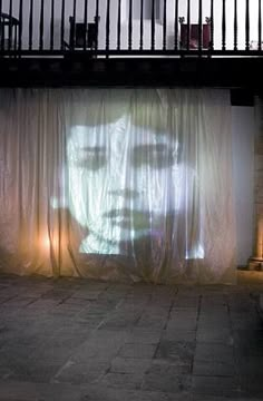 a person standing in front of a large screen on the side of a building at night