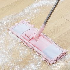 a pink dust mop is laying on the floor