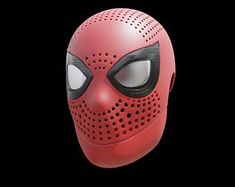 a red mask with black eyes on a black background