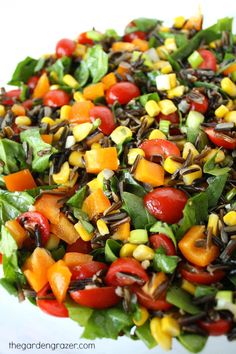 a salad with tomatoes, corn and other vegetables