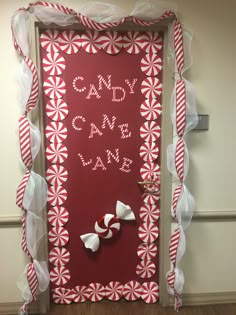 a door decorated with red and white candy canes, bows and the words candy land on it