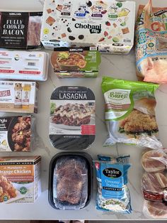 an assortment of frozen food is laid out on the counter top, including meats and vegetables