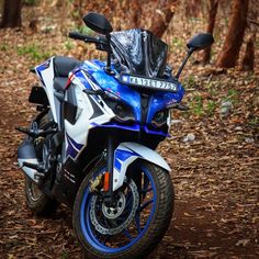 a blue and white motorcycle parked in the woods