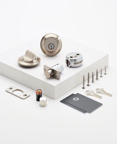 an assortment of door knobs and keys on a white surface with a card holder