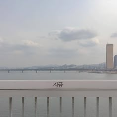 a view of the water and bridge from across the river with chinese characters on it