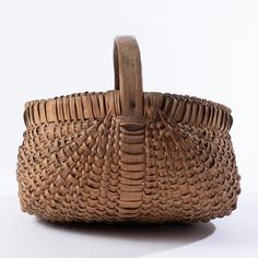 a woven basket sitting on top of a white table next to a wooden handlebar