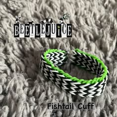 two bracelets with green and white braiding on top of a gray blanket next to the words beetlejuice