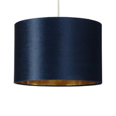 a blue lamp shade hanging from a ceiling fixture with a white light in the background