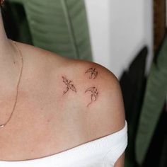 a woman's shoulder with three small birds on it