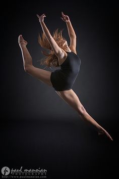 a woman in black shirt and shorts doing a dance move with her legs spread out