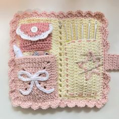 a crocheted pink and white baby blanket with pins, needles, and scissors