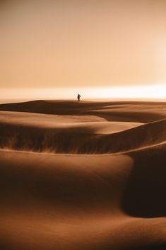 a lone person standing in the middle of a desert