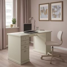 a white desk with a laptop computer on top of it next to a chair and potted plant