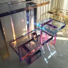 three different colored glass tables sitting on top of each other