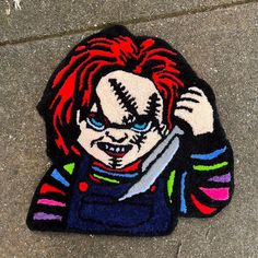 a patch with a clown holding a knife on the ground in front of a sidewalk