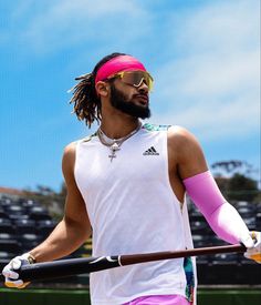 a man holding a tennis racquet on top of a tennis court with a pink headband