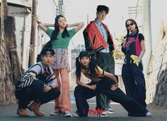 four young people posing for a photo on the street