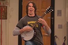 the young man is playing an instrument in his living room