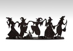 three metal witches standing next to each other on top of a white surface with black speckles