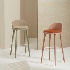 two stools sitting next to each other in front of a white wall and floor