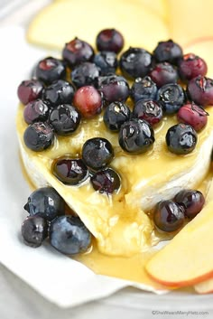 blueberries, apples and cheese are on a plate