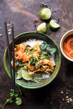 a green bowl filled with food next to chopsticks