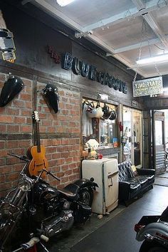 the inside of a motorcycle shop with motorcycles parked in front of it and guitars hanging from the ceiling