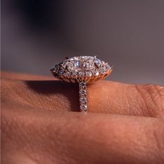 a close up of a person's hand with a diamond ring on their finger