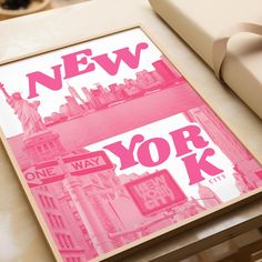 a new york city poster is displayed on a table next to a gift box and other items