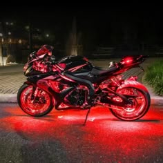 two motorcycles are parked on the side of the road with red lights in front of them