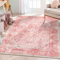 a living room area with a rug, chair and teddy bear