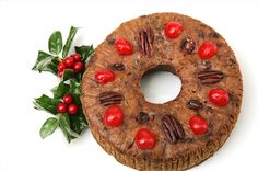 a chocolate cake with pecans and cherries on the top, surrounded by holly