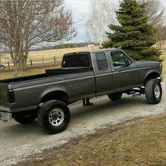 a gray truck parked on top of a dirt road