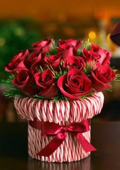 a bouquet of red roses in a candy cane box with the words sofyguapay cuta