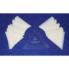 three triangle shaped plastic pieces on a blue cloth with white writing and an image of two triangles