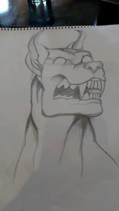 a drawing of a demon with its mouth open and fangs out, sitting on top of a table