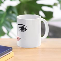 a white coffee mug with an image of a woman's face painted on it