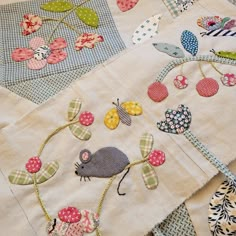 a close up of a patchwork table cloth with various appliques on it